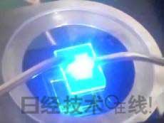   發(fā)光試驗中的LED元件。基板尺寸：1cm見方，元件尺寸：0.3mm見方，注入電流：約200mA，中心波長：450nm 